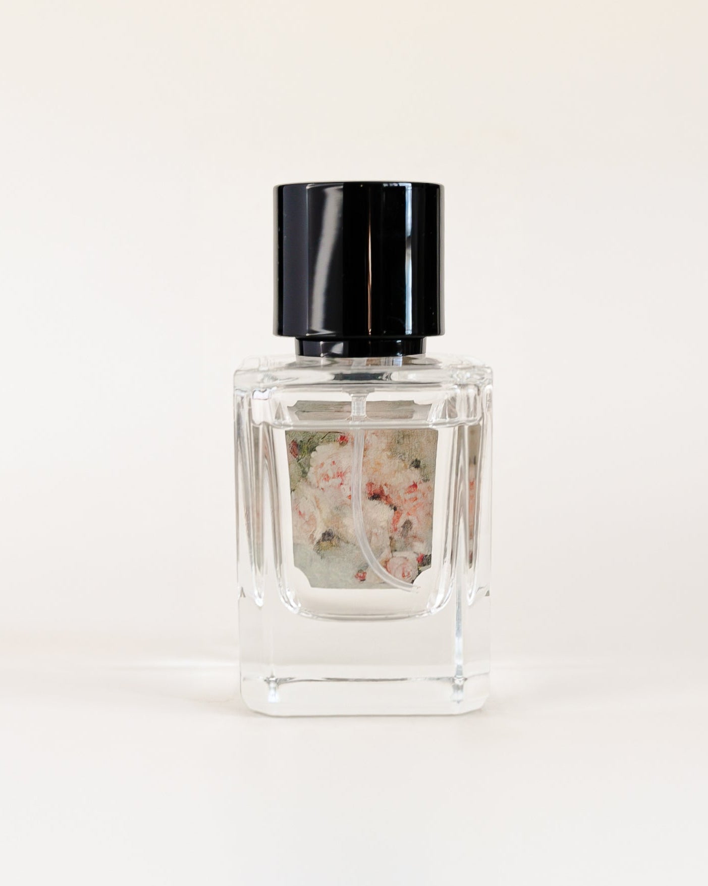 Small glass bottle with a black cap on a white background