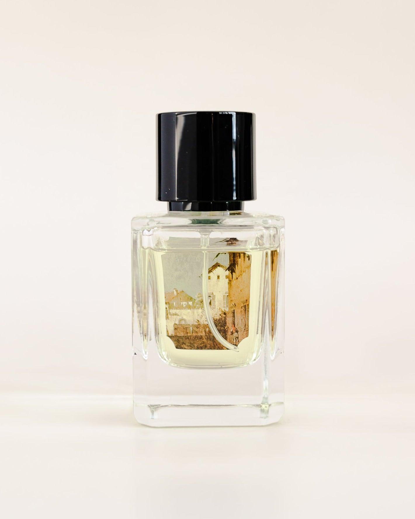 Perfume bottle with black cap on a light beige background