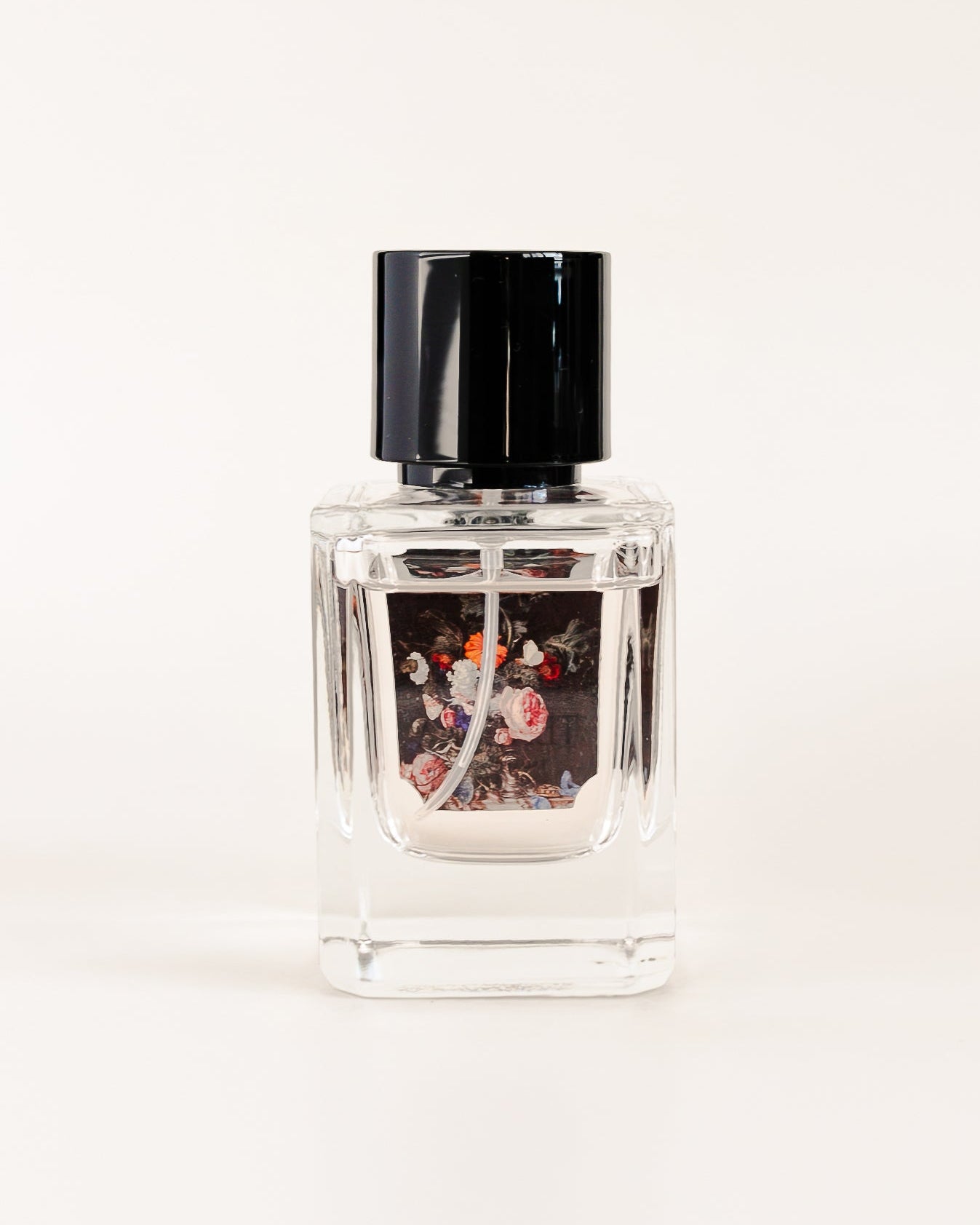 Clear nail polish bottle with black cap on a white background