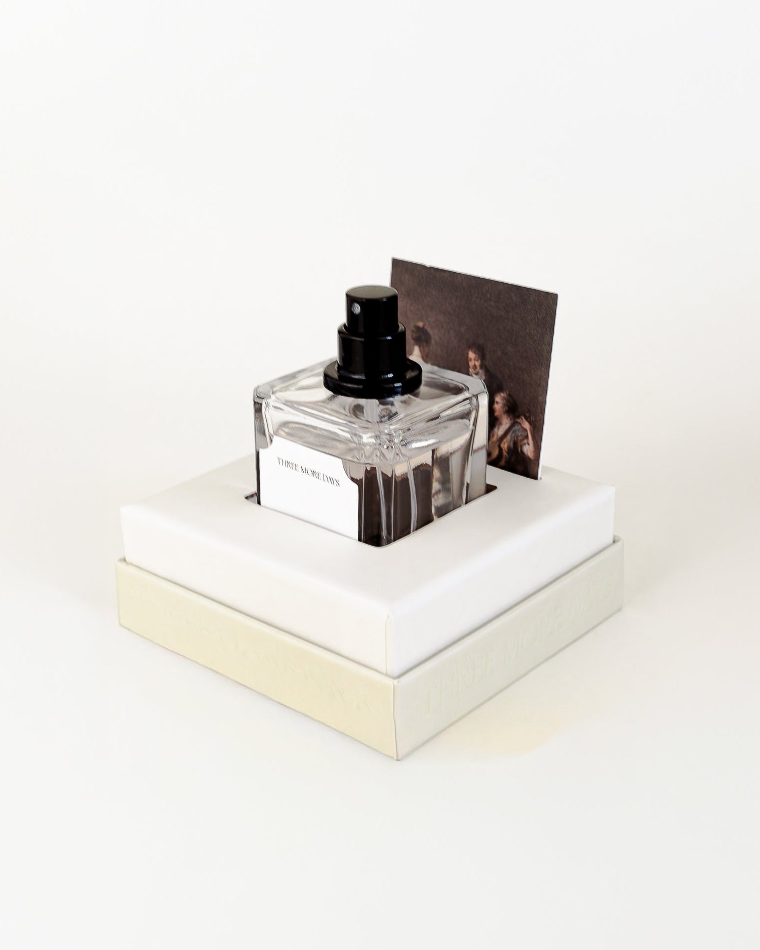 Small glass bottle with a black cap on a white platform against a white background