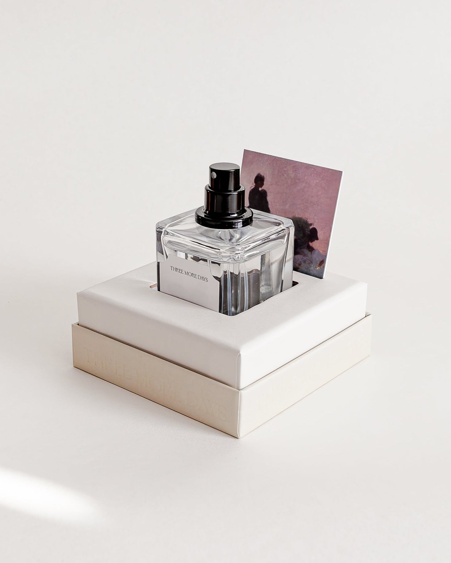 Perfume bottle on a white platform with a white background