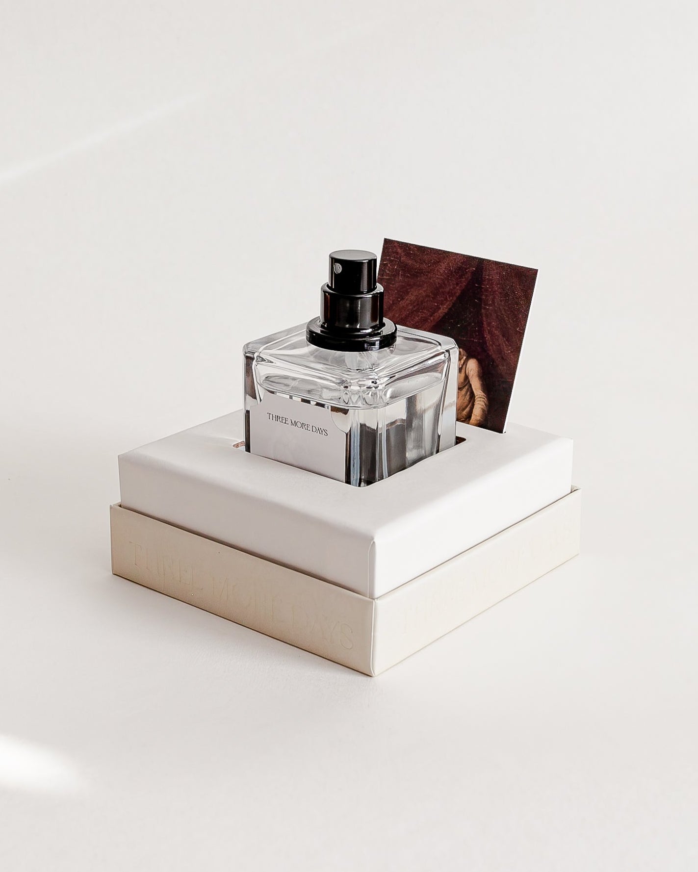 Perfume bottle on a white platform with a white background