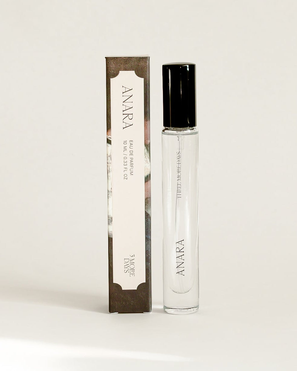 A small cylindrical cosmetic bottle with a black cap stands next to its matching rectangular box on a draped white paper backdrop. The packaging features a dark brown and white design with the brand name 'SOLIS' visible.