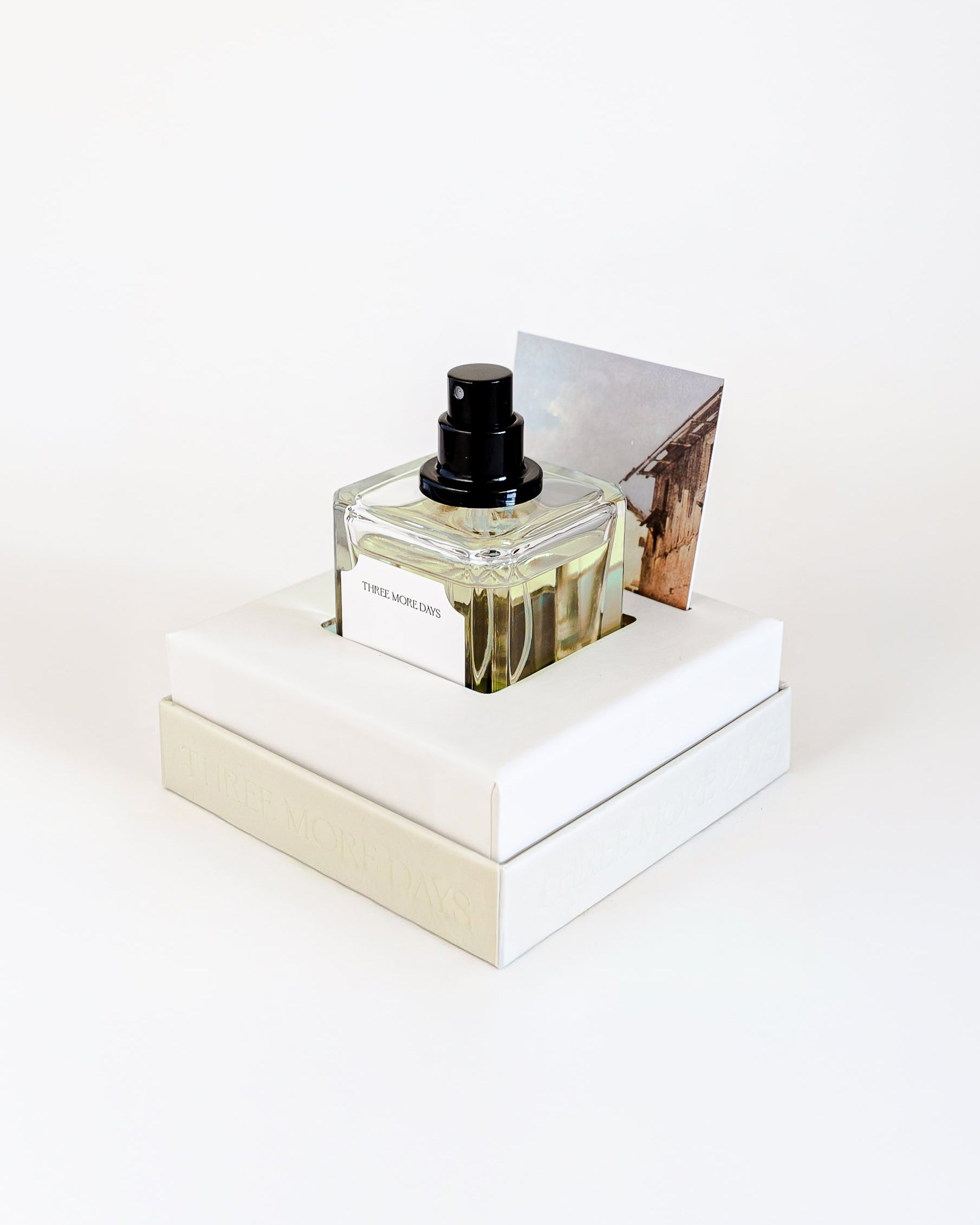 Small bottle of perfume on a white platform with a white background