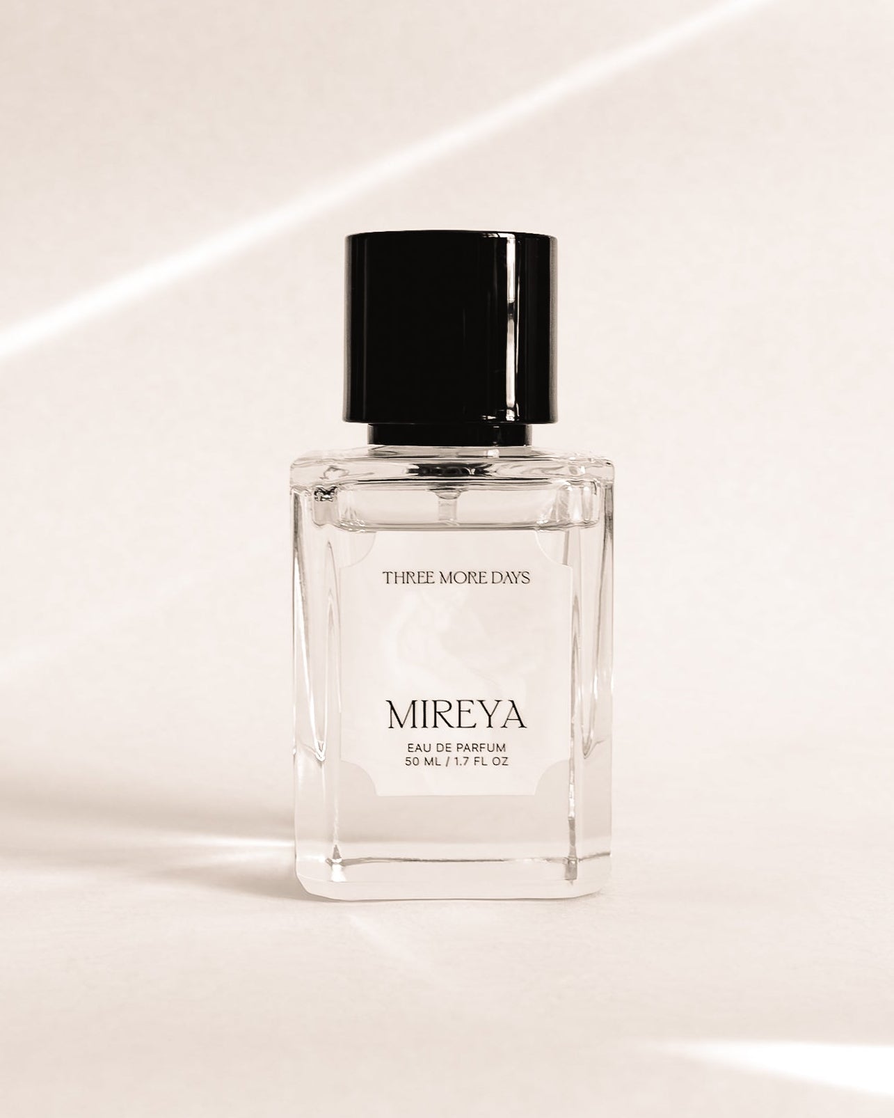 Perfume bottle labeled 'Mireya' on a reflective surface